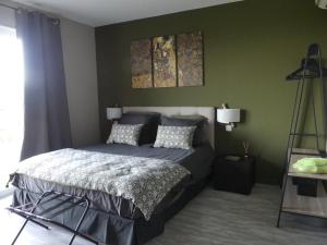 een slaapkamer met een bed en een groene muur bij Casa Peppina - Chez Tonio et Sylvie in Sari Solenzara