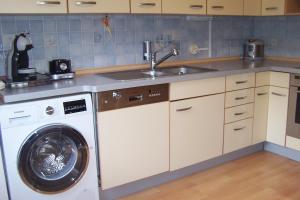 een keuken met een wasmachine en een wastafel bij Ferienwohnung Sakowski in Lörrach
