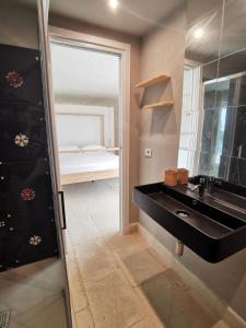 a bathroom with a black sink and a bedroom at Casa Del Mandorlo in Noto