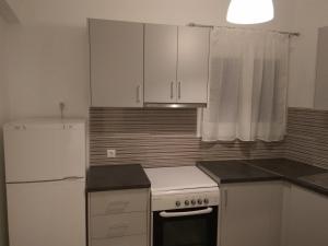 a kitchen with white cabinets and a white refrigerator at AMARYLLIS in Batsi