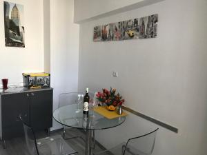 a glass table with a bottle of wine and flowers on it at Universitate Residence in Bucharest