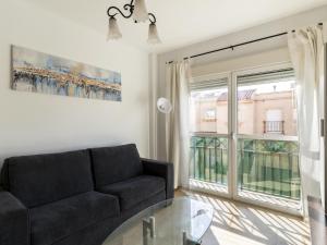 sala de estar con sofá y mesa de cristal en Belvilla by OYO Apartment in Roquetas de Mar en Aguadulce