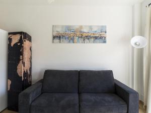 un sofá en una sala de estar con una pintura en la pared en Belvilla by OYO Apartment in Roquetas de Mar en Aguadulce