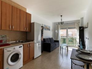 cocina con lavadora y sala de estar. en Belvilla by OYO Apartment in Roquetas de Mar en Aguadulce