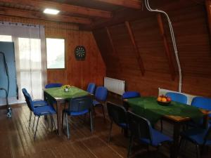 a conference room with two tables and blue chairs at CHATA POD VLEKOM in Dedinky