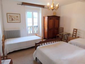 a bedroom with two beds and a chandelier at La Mare aux 3 Diables in Fresney-le-Vieux +71 photos