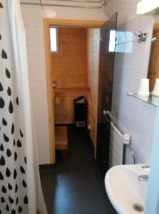 La petite salle de bains est pourvue d'un lavabo et de toilettes. dans l'établissement Hotelli Ravintola Tiilikka, à Rautavaara
