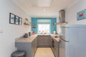 a kitchen with a refrigerator and a sink in it at Beach Cottage in Lytham St Annes