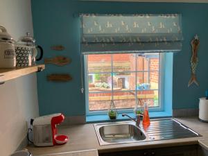a kitchen with a sink and a window at Beach Cottage in Lytham St Annes +12 photos