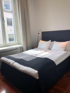 1 cama grande en un dormitorio con 2 ventanas en Grand Hotel Falkenberg, en Falkenberg