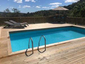 a swimming pool on a deck with an umbrella at Studio Colina in Tavira