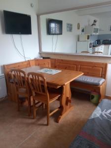 une table en bois avec deux chaises et une télévision dans l'établissement La Collinette, à Saint-Laurent-du-Cros