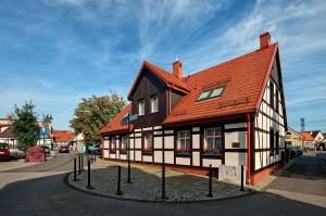 un edificio marrón y blanco con techo rojo en Chata Rybacka Saule, en Ustka