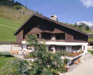 a house with a table and chairs in front of it at Apartments Residence Alta Badia in Colfosco