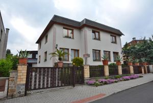 Biały dom z płotem i kwiatami w obiekcie Apartmány Karlovy Vary w Karlowych Warach