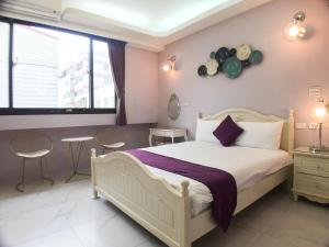 1 dormitorio con 1 cama, mesa y sillas en Hualien Dawan B&B en Jian