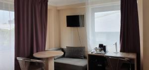 オーバーウルゼルにあるホテル レジデンツ オーバーウルゼラー ホフのソファ、テーブル、窓が備わる客室です。