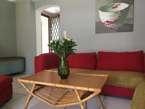 eine Vase mit Blumen auf einem Tisch im Wohnzimmer in der Unterkunft 2 appartements calmes in Fréjus
