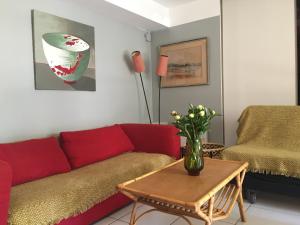 ein Wohnzimmer mit einem roten Sofa und einem Tisch in der Unterkunft 2 appartements calmes in Fréjus