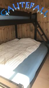 a bunk bed with white sheets on top of it at Rytterlia 6 in Drangedal