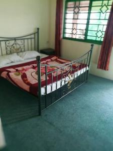 a bedroom with a bed with a metal frame at Nathia Heights Hotel in Bāzār