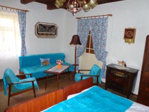 a living room with a blue couch and chairs at Nevšední ubytování jako u babičky ve stylu 60.let in Budkovce