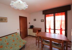 a living room with a table and a chair at Villa Gloria appartamento E01 in Rosolina Mare