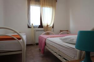 a small bedroom with two beds and a window at Villa Gloria appartamento E01 in Rosolina Mare