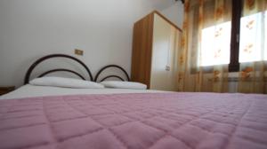 a bedroom with a pink bed and a window at Villa Gloria appartamento E01 in Rosolina Mare