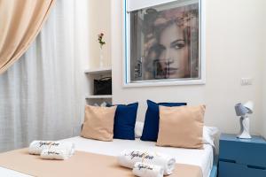 een bed met kussens en een foto aan de muur bij NapoliViva in Napels