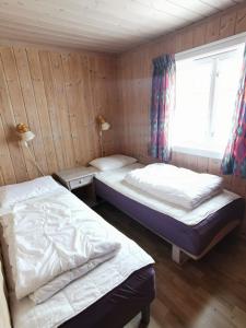 Duas camas num quarto com uma janela em Ørterstølen Hytter em Gol