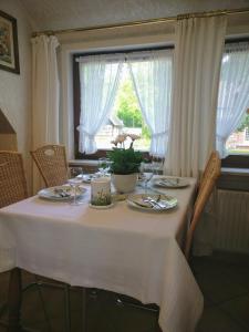 una mesa de comedor con un mantel blanco. en Ferienwohnungen / Ferienhaus Wahlers, en Bispingen