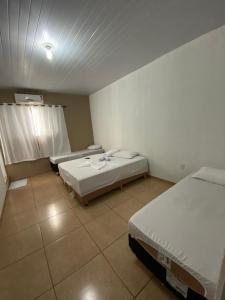 a room with two beds and a window in it at Hotel 7 in Três Lagoas