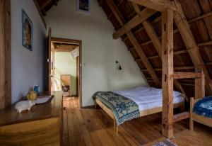 een slaapkamer met een bed en een houten plafond bij MorzeLas niebieski domek in Białowieża