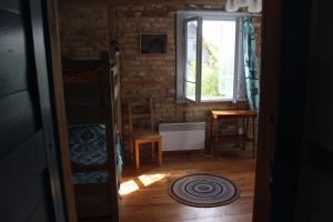 een kleine kamer met een raam en een houten vloer bij MorzeLas niebieski domek in Białowieża