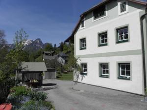 une maison blanche avec une cour et un bâtiment dans l'établissement Ausseer Kleeblatt, à Bad Aussee