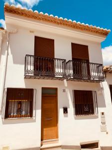 Cette maison blanche dispose de 2 balcons et d'une porte. dans l'établissement Casa del Herrero, à Chulilla