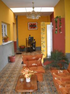 a living room with orange couches and a table at Hostal Isidoros in La Paz