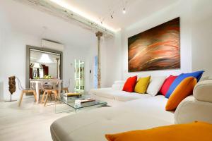 a living room with a white couch with colorful pillows at Art Chapiz Apartments in Granada