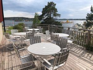 um deque com mesas e cadeiras e vista para a água em Sjövillan B&B em Vaxholm