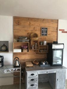 a kitchen with a table with a microwave and a counter at Chambre d´hôtes La Jonchère in Les Herbiers