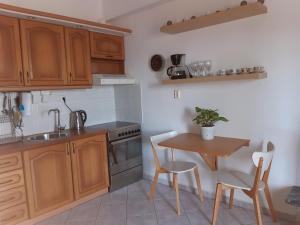 a kitchen with wooden cabinets and a table with chairs at Iraklitsa Bay View in Iraklitsa