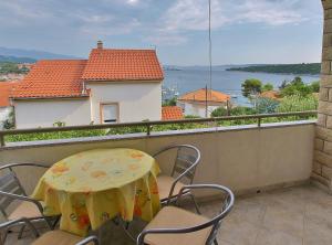 a table and chairs on a balcony with a view of the water at Apartments Biserka in Rab