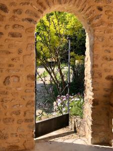 un arco in un muro di mattoni con finestra con albero di Gites Lydil a Nyons