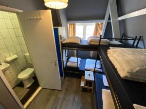 a small room with two bunk beds and a bathroom at Hostel Cosmos Amsterdam in Amsterdam