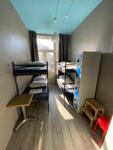 a dorm room with bunk beds and a refrigerator at Hostel Cosmos Amsterdam in Amsterdam