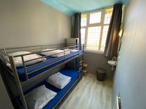 a room with three bunk beds and a window at Hostel Cosmos Amsterdam in Amsterdam