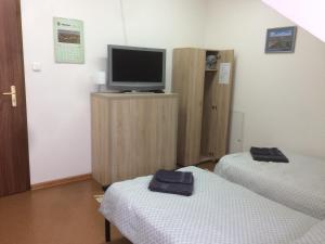 Zimmer mit 2 Betten und einem TV auf einem Schrank in der Unterkunft Ekomarina - Pokój noclegowy 1 in Angerburg