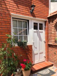 a white door and a window on a brick building at Garsonjera Zvezdara in Belgrade