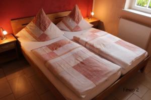 een bed met twee lakens en kussens erop bij Ferienhof Cunnersdorf in Kurort Gohrisch